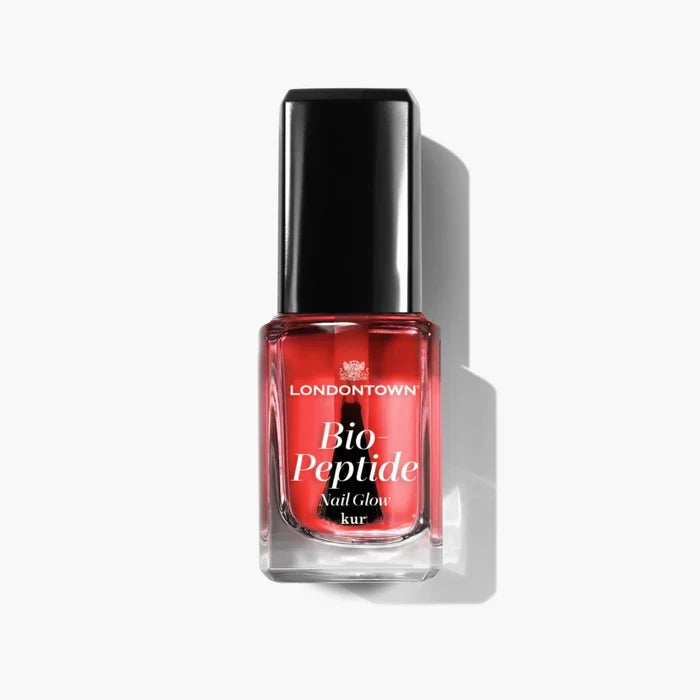 Bottle of LONDONTOWN Bio Peptide Nail Glow in sheer red with a black cap, perfect for a glowing skin aesthetic.