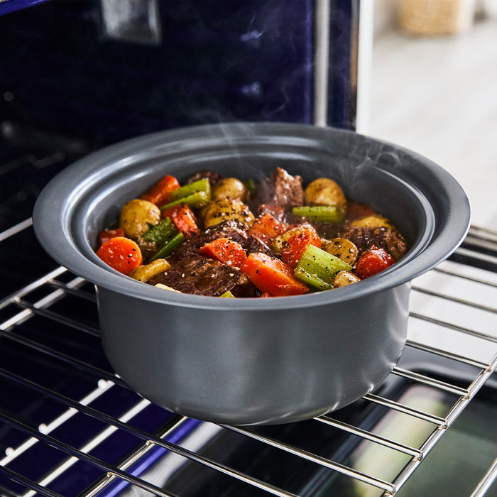 Bistro 4-quart slow cooker with in-pot browning, macadamia color, cooking beef stew with vegetables, steam rising.