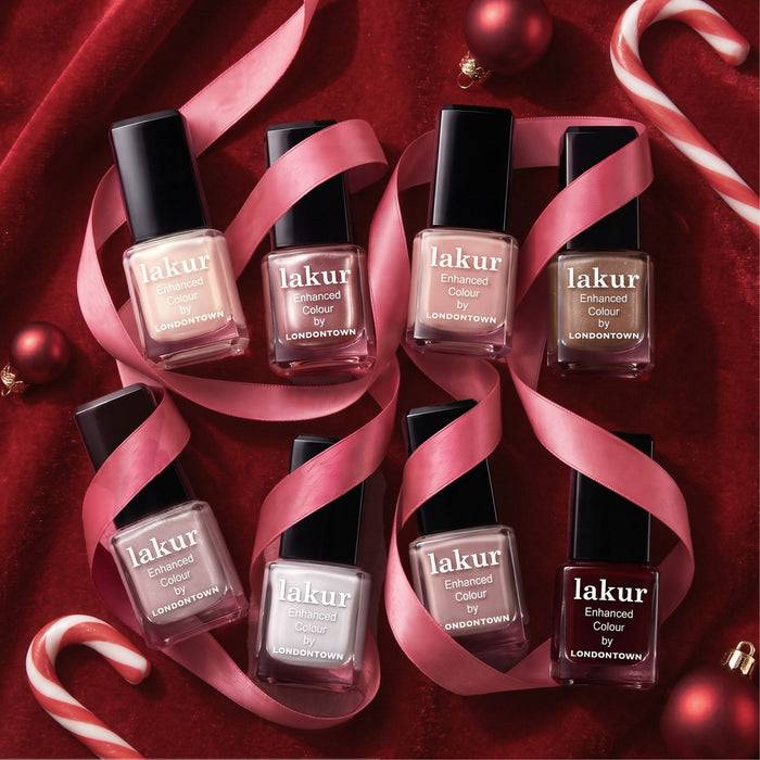 Six bottles from the LONDONTOWN Candy Cane Cuties Holiday Set are arranged on red velvet with pink ribbon, Christmas ornaments, and candy canes to create a stunning holiday gift display. This curated set is perfect for adding a festive touch to any celebration.
