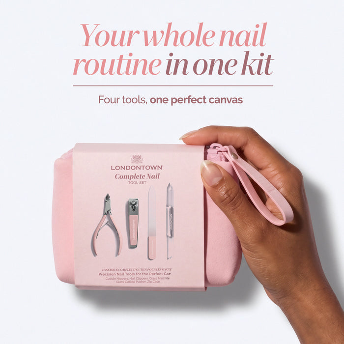 A hand holds a pink pouch containing LONDONTOWN’s Complete Nail Tool Set, with four precision nail tools visible in the packaging for creating the perfect canvas.