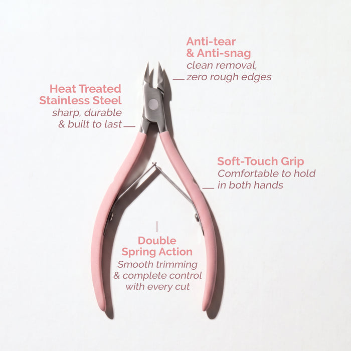 The LONDONTOWN Cuticle Nippers - Pink are shown with labels showcasing their salon-grade features, including stainless steel construction, a soft-touch grip, anti-snag tips, and double spring action for precise cutting.