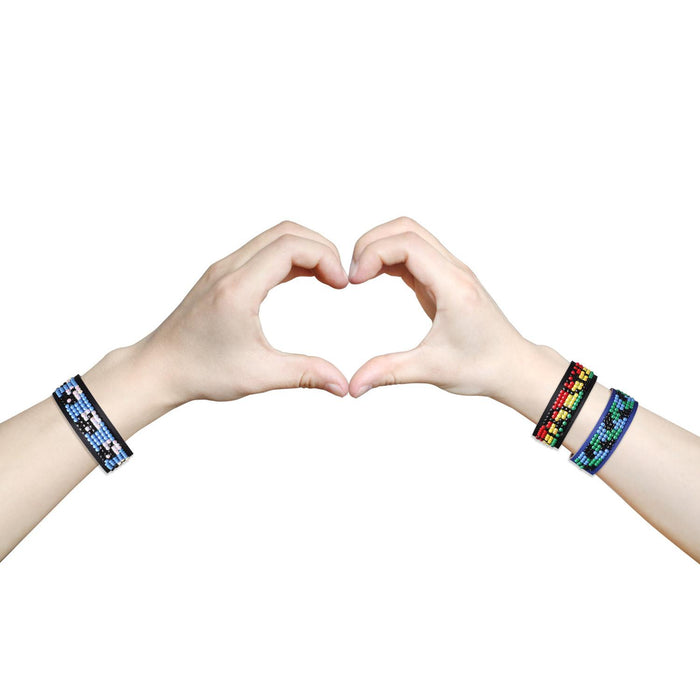 Two hands adorned with vibrant Diamond Dotz Peace Bracelets from Diamond Dotz come together to form a heart shape against a white background.