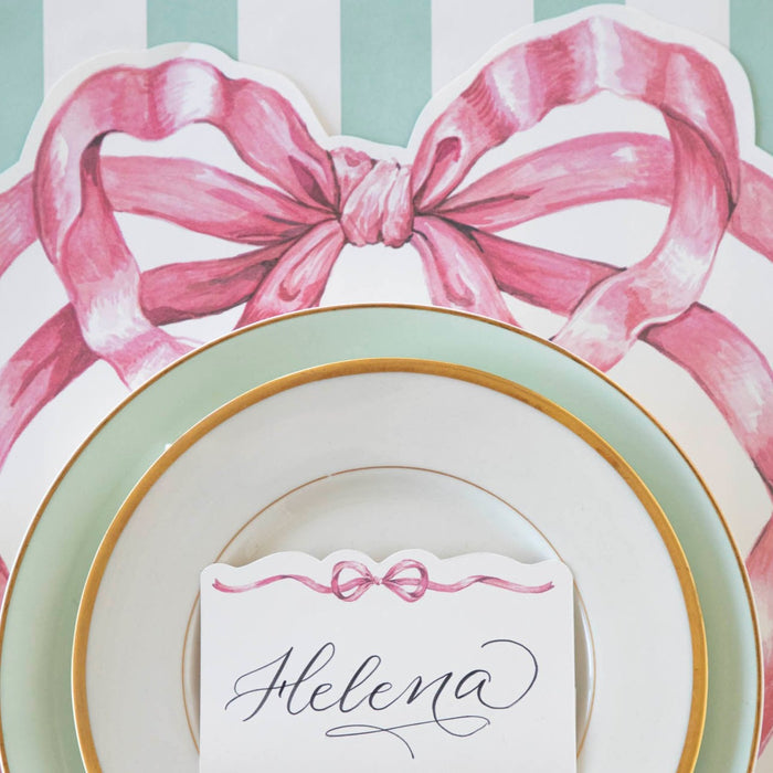 A whimsical Die-cut Pink Bow Placemat adorned with a Hester & Cook pink bow.