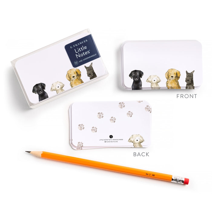 Notebook with dog illustrations, pencil, and small tin on a white background.