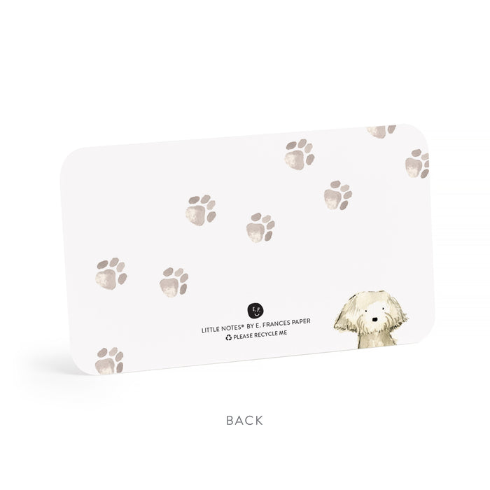 Back of a little note with paw print pattern and dog illustration on a white background.