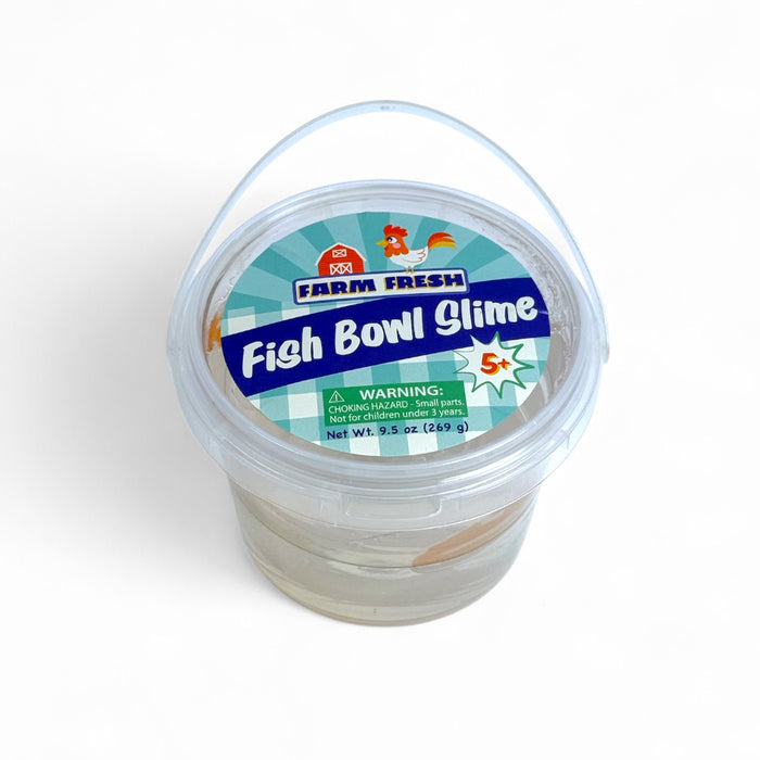 A clear plastic tub of Farm Fresh Fish Bowl Slime by Farm Fresh features a blue lid, cartoon graphics, and translucent goldfish slime. This 9.5 oz (269 g) sensory toy is suitable for ages 5 and up.