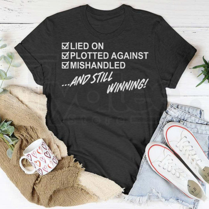 "Lied On, Plotted Against, Still Winning" Unisex T-Shirt – Resilience Graphic Tee
