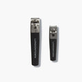 The LONDONTOWN Nail Clipper Duo Set - Black features two metal nail clippers with black handles, displayed side by side on a white background for a precise cut every time.