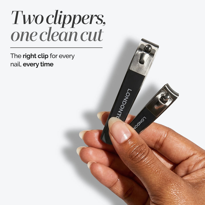 A hand holds two different-sized black nail clippers from the LONDONTOWN Nail Clipper Duo Set, displayed against a white background. Above, text highlights precise and clean nail clipping with two versatile sizes.