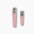 The LONDONTOWN Nail Clipper Duo Set - Pink features two metal nail clippers with pink grips, displayed on a white background. The set includes one large and one small clipper, both designed for precise, clean cuts and facing upward.