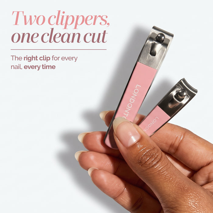 A hand holds two pink nail clippers—one large and one small—from the Nail Clipper Duo Set by LONDONTOWN. Text on the image highlights the set’s versatility with two sizes, ensuring a clean cut every time.
