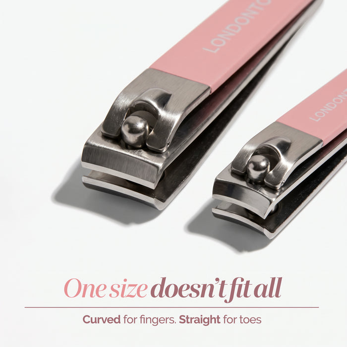 Two pink LONDONTOWN Nail Clipper Duo Set clippers in two sizes—one large, one small—are displayed side by side on a white background. The text below reads: “One size doesn’t fit all. Curved for fingers, straight for toes—for a clean cut every time.”.