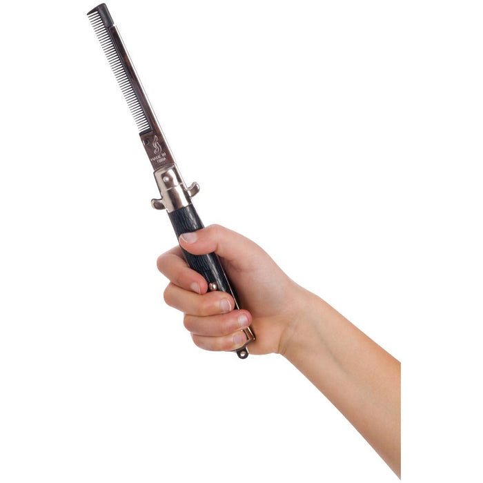 A hand holding the Neato! Switchblade Comb, a novelty grooming accessory by Neato!, featuring a black handle and metallic blade, set against a white background.
