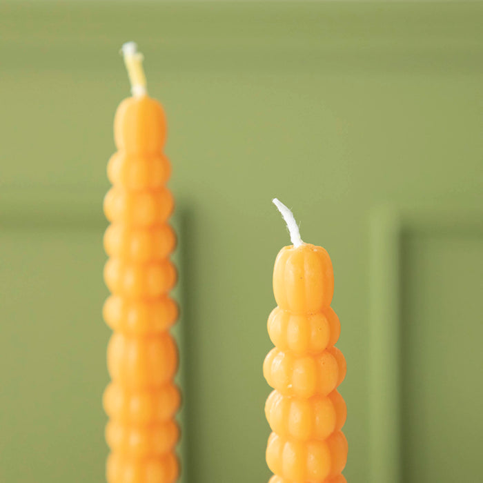 Close-up of the orange pumpkin taper candle.