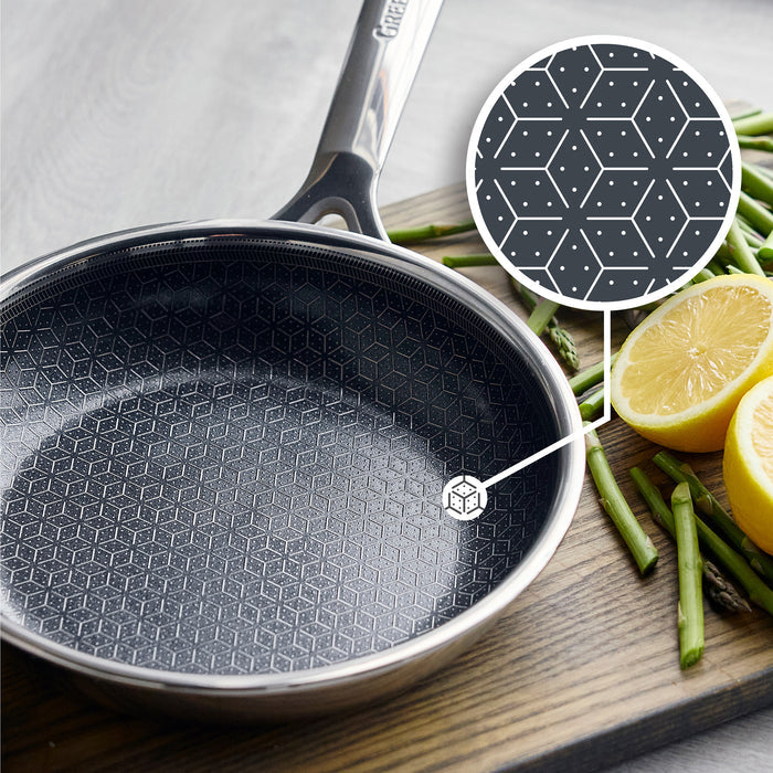 Hybrid ceramic nonstick frypan next to asparagus and lemon halves on a wooden board.