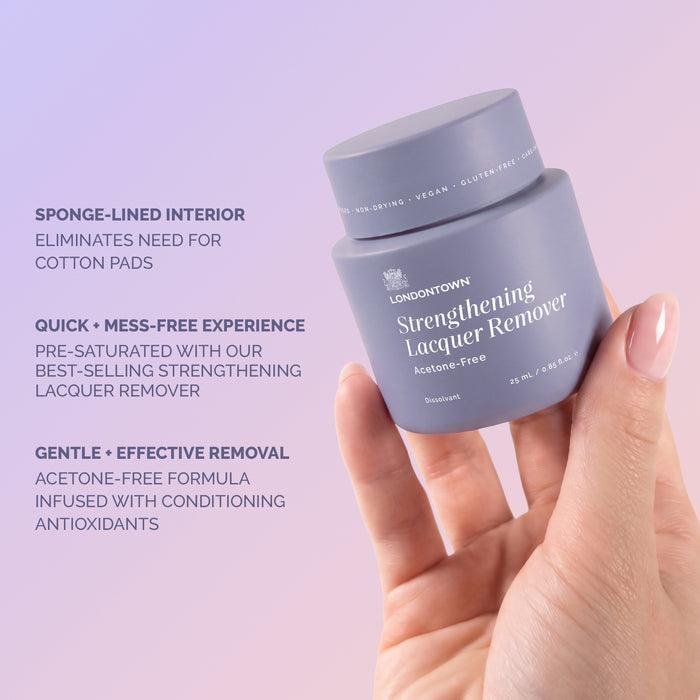 A hand holds LONDONTOWN’s Strengthening Lacquer Remover Pot. Text highlights its sponge-lined interior and pre-saturated, acetone-free formula infused with conditioning antioxidants, allowing for an effortless nail reset—simply dip, twist, and reveal beautifully clean tips.