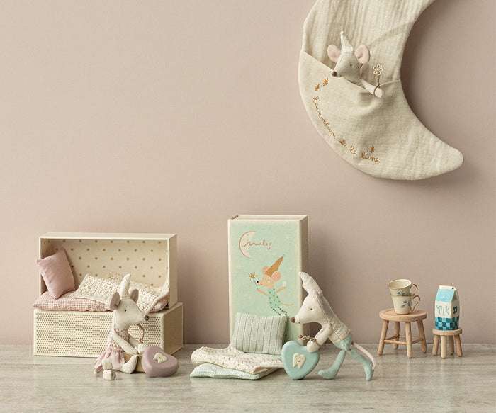Children's room with toys, a crib, and decorative items on a wooden floor.