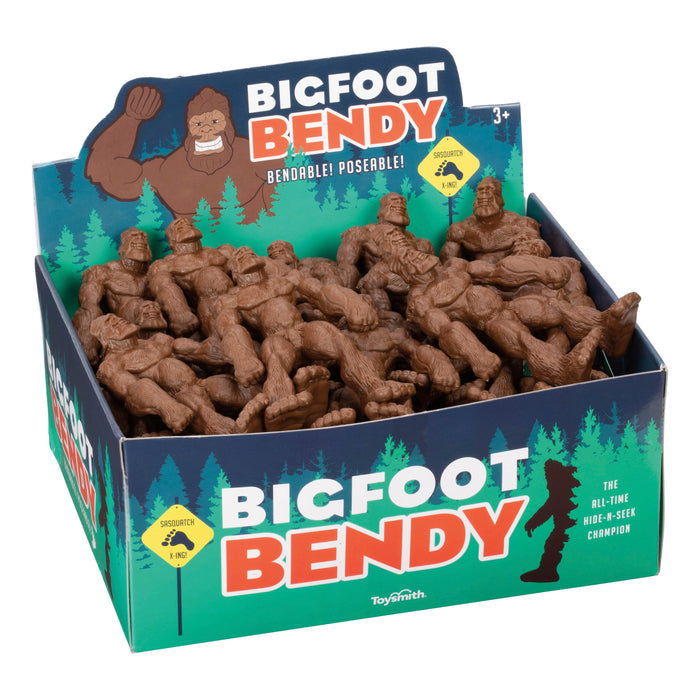 A display box of brown Toysmith Bigfoot Bendy figures features tree and cartoon Bigfoot graphics, labeled "Toysmith Bigfoot Bendy" and "Bendable! Poseable! The All-Time Hide-and-Seek Champion.