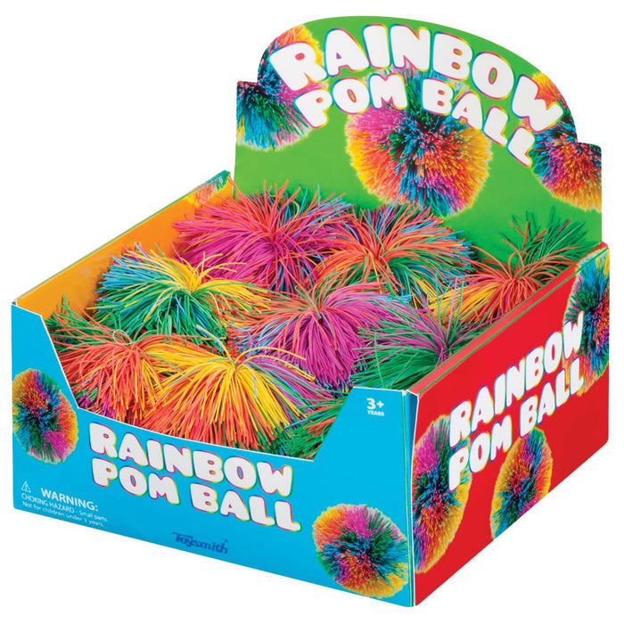 The Toysmith Rainbow Pom Ball display box by Toysmith holds spiky, brightly colored sensory balls with playful graphics and bold text, ideal for children ages 3+.
