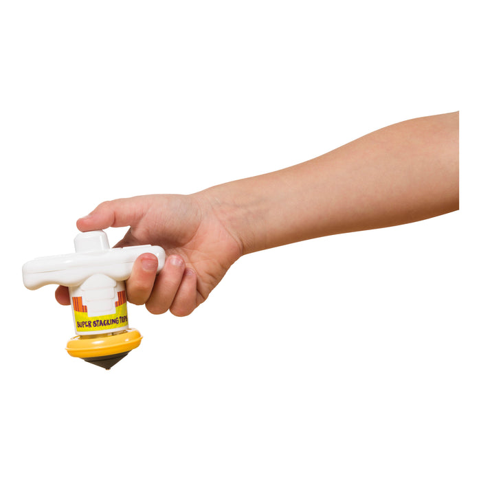 A hand holds a yellow and white Toysmith Super Stacking Tops toy against a plain white background.