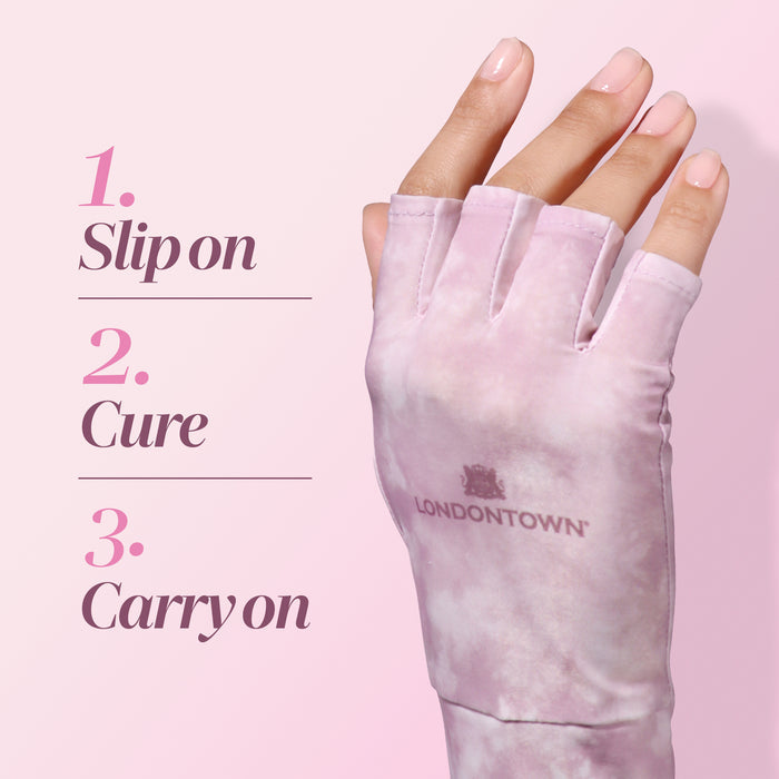 A hand wearing a pink, fingerless LONDONTOWN UV Glove is shown next to text reading: “1. Slip on 2. Cure 3. Carry on.” The nails are manicured and the pink background highlights how these gel-padded gloves combine style with effective hand protection during UV exposure.